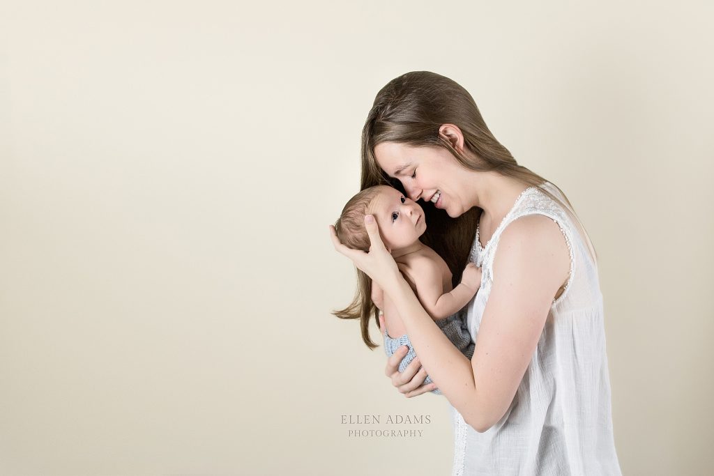 This is a newborn photography image of a mom holding her older newborn baby, photographed by Ellen Adams Photography.