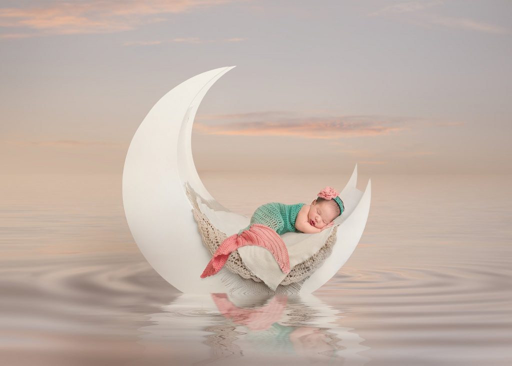 Huntsville newborn photography picture of 11 day old baby dressed as a mermaid in the sea, captured by Ellen Adams Photography.