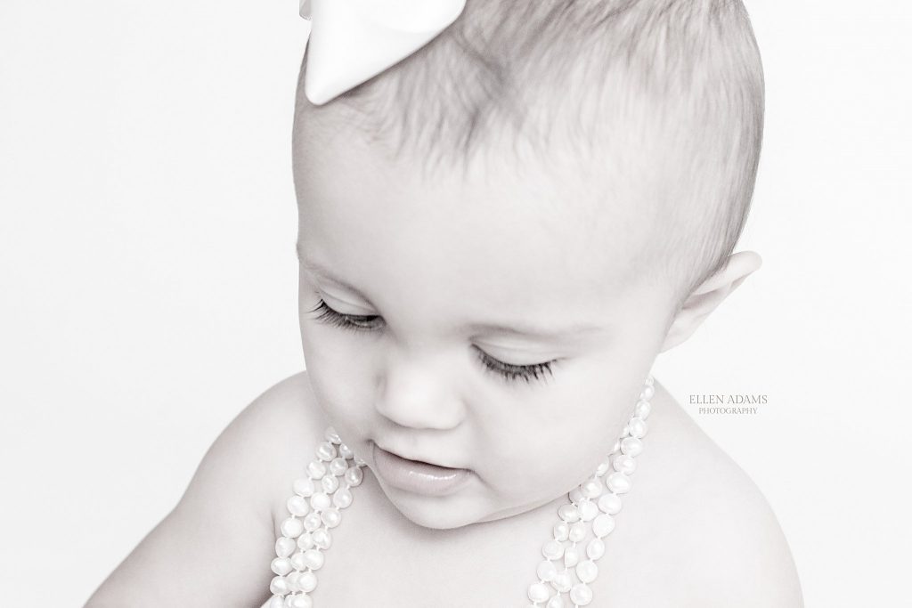 Baby photographer Madison, AL Ellen Adams Photography picture of baby looking down in pearls.