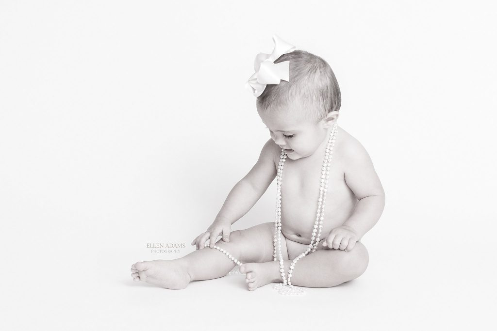 One year photos Huntsville AL picture of baby girl in pearls by Ellen Adams Photography.