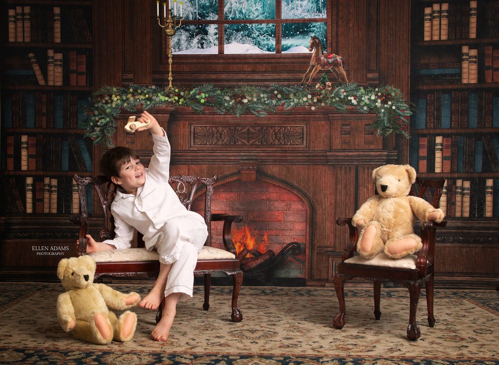 Christmas picture in Huntsville AL by Ellen Adams Photography of a boy playing with a toy airplane.