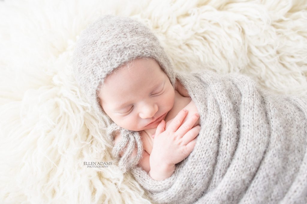 Newborn photography in Huntsville, AL image of baby wrapped in gray swaddle